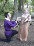 Hermia shares a joke with a kneeling Lysander