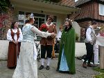 The Shepherdess watches on as Perdita tries to bribe Polixenes and Camilla with pot plants